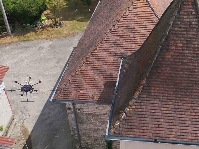 Photo du drone en plein démoussage de la toiture d'un pigeonnier